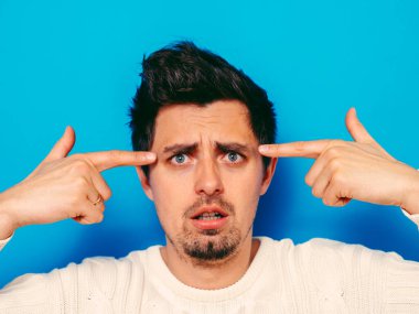 Parmağıyla şakağına dokunan öfkeli bir adamın yakın plan portresi. Delirdin mi sen??