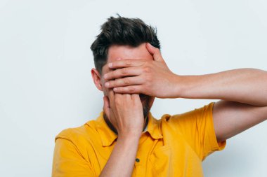 Adam elleriyle yüzünü örttü.