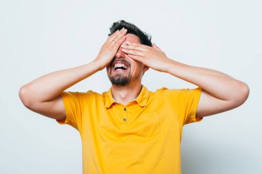 Adam elleriyle yüzünü örttü.