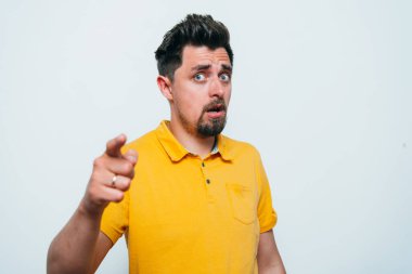 Genç adam işaret parmağını kameraya doğru gösteriyor.