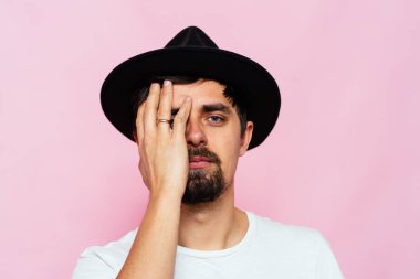  Adam elleriyle yüzünü kapatıyor.