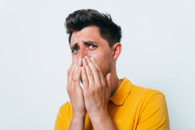 Adam gülüyor ve ağzını kapatıyor.