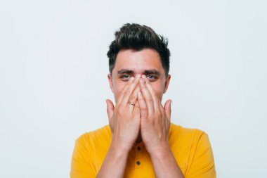 Adam gülüyor ve ağzını kapatıyor.