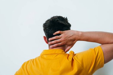 Kafasını tutarak. Arkadaki adam