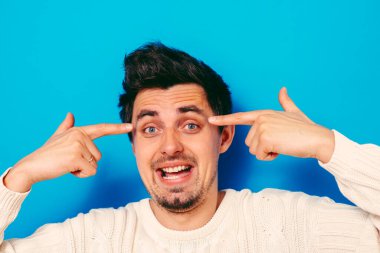 Parmağıyla şakağına dokunan öfkeli bir adamın yakın plan portresi. Delirdin mi sen??