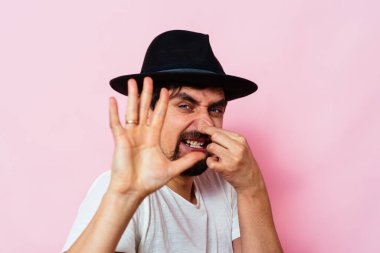 Leş gibi kokuyor. Adamın burnunu kapatır.