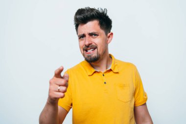 Genç adam işaret parmağını kameraya doğru gösteriyor.