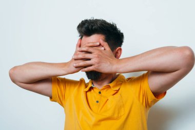 Adam elleriyle yüzünü örttü.