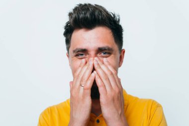 Adam gülüyor ve ağzını kapatıyor.