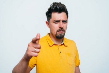 Genç adam işaret parmağını kameraya doğru gösteriyor.