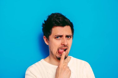 Avrupa görünümlü bir erkek kusmaya neden olur. Parmaklarını ağzına koyar, mide bulantısı.