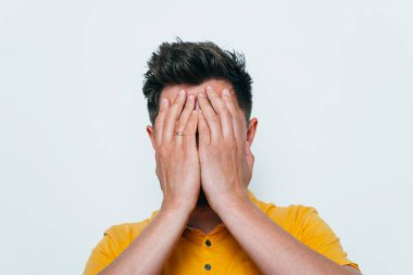 Adam elleriyle yüzünü örttü.