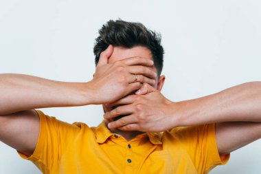 Adam elleriyle yüzünü örttü.