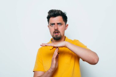 Bir adam, ellerin mola verdiğini gösterir. Gri bir arkaplanda.