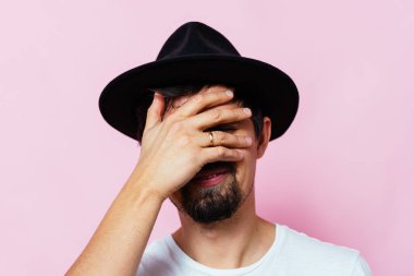  Adam elleriyle yüzünü kapatıyor.