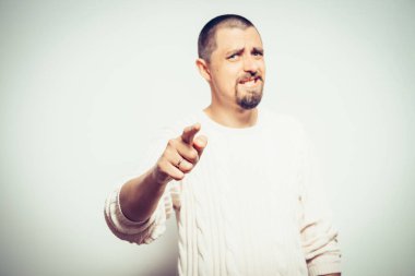 Genç adam işaret parmağını kameraya doğru gösteriyor.