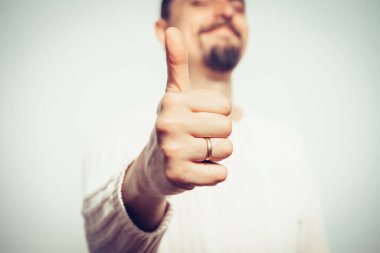 Adam baş parmağını gösteriyor.