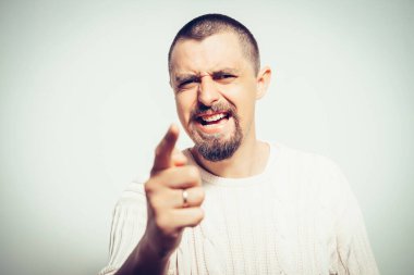 Genç adam işaret parmağını kameraya doğru gösteriyor.