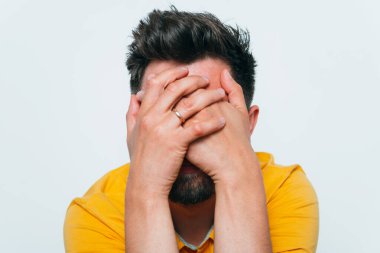 Adam elleriyle yüzünü örttü.