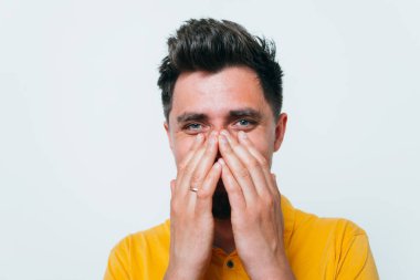 Adam gülüyor ve ağzını kapatıyor.