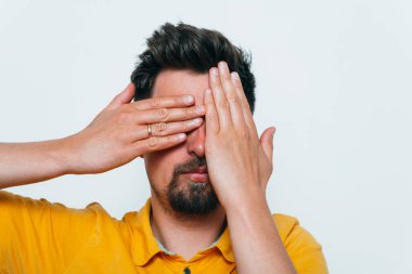 Adam elleriyle yüzünü örttü.