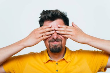 Adam elleriyle yüzünü örttü.