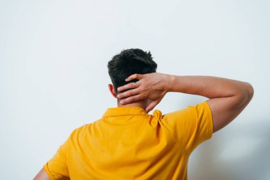 Kafasını tutarak. Arkadaki adam