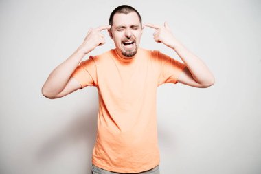 Parmağıyla şakağına dokunan öfkeli bir adamın yakın plan portresi. Delirdin mi sen??