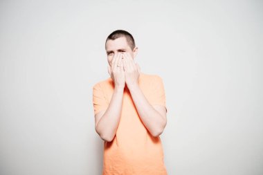 Adam gülüyor ve ağzını kapatıyor.