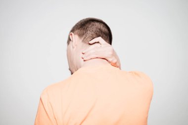 Kafasını tutarak. Arkadaki adam