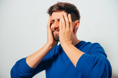 Adam elleriyle yüzünü örttü.