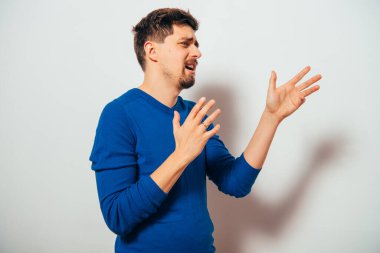 Gri arka planda poz veren genç adam