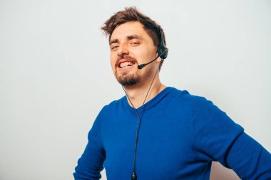 Gri arka planda poz veren genç adam