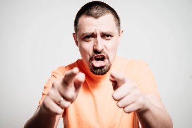 Genç adam işaret parmağını kameraya doğru gösteriyor.