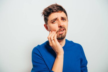 Gri arka planda poz veren genç adam