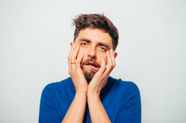 Gri arka planda poz veren genç adam