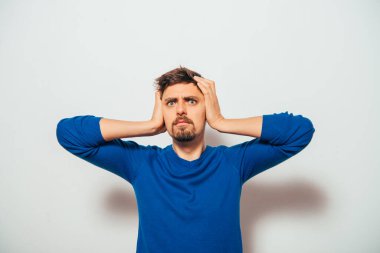 Gri arka planda poz veren genç adam