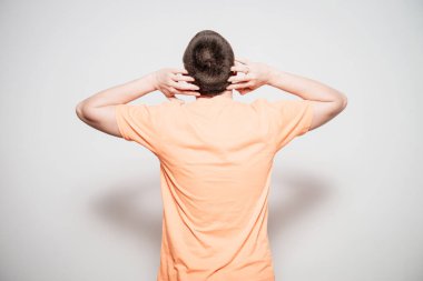 Kafasını tutarak. Arkadaki adam