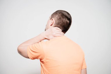 Kafasını tutarak. Arkadaki adam