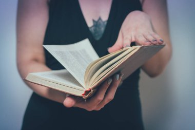Elinde kitap olan kadın.