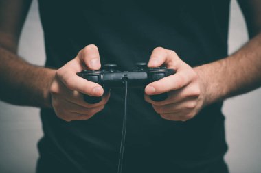 Oyun konsolunda oyun çubuğunda oynayan adam