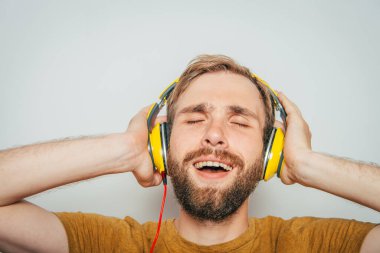 Kulaklıklı bir adam stüdyo geçmişine karşı.