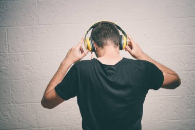 Kulaklıklı bir adam stüdyo geçmişine karşı.