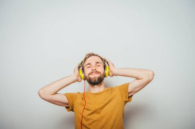 Kulaklıklı bir adam stüdyo geçmişine karşı.