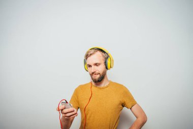 Kulaklıklı bir adam stüdyo geçmişine karşı.