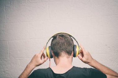 Kulaklıklı bir adam stüdyo geçmişine karşı.