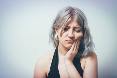 Diş ağrısı çeken kadın stüdyo geçmişine karşı