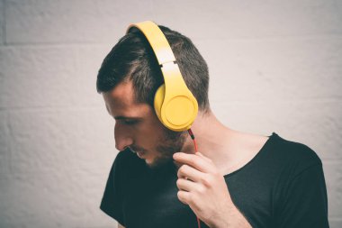 Kulaklıklı bir adam stüdyo geçmişine karşı.