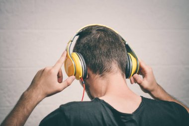 Kulaklıklı bir adam stüdyo geçmişine karşı.