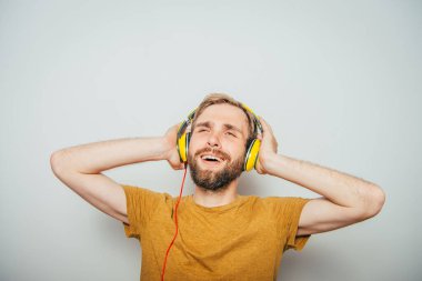 Kulaklıklı bir adam stüdyo geçmişine karşı.